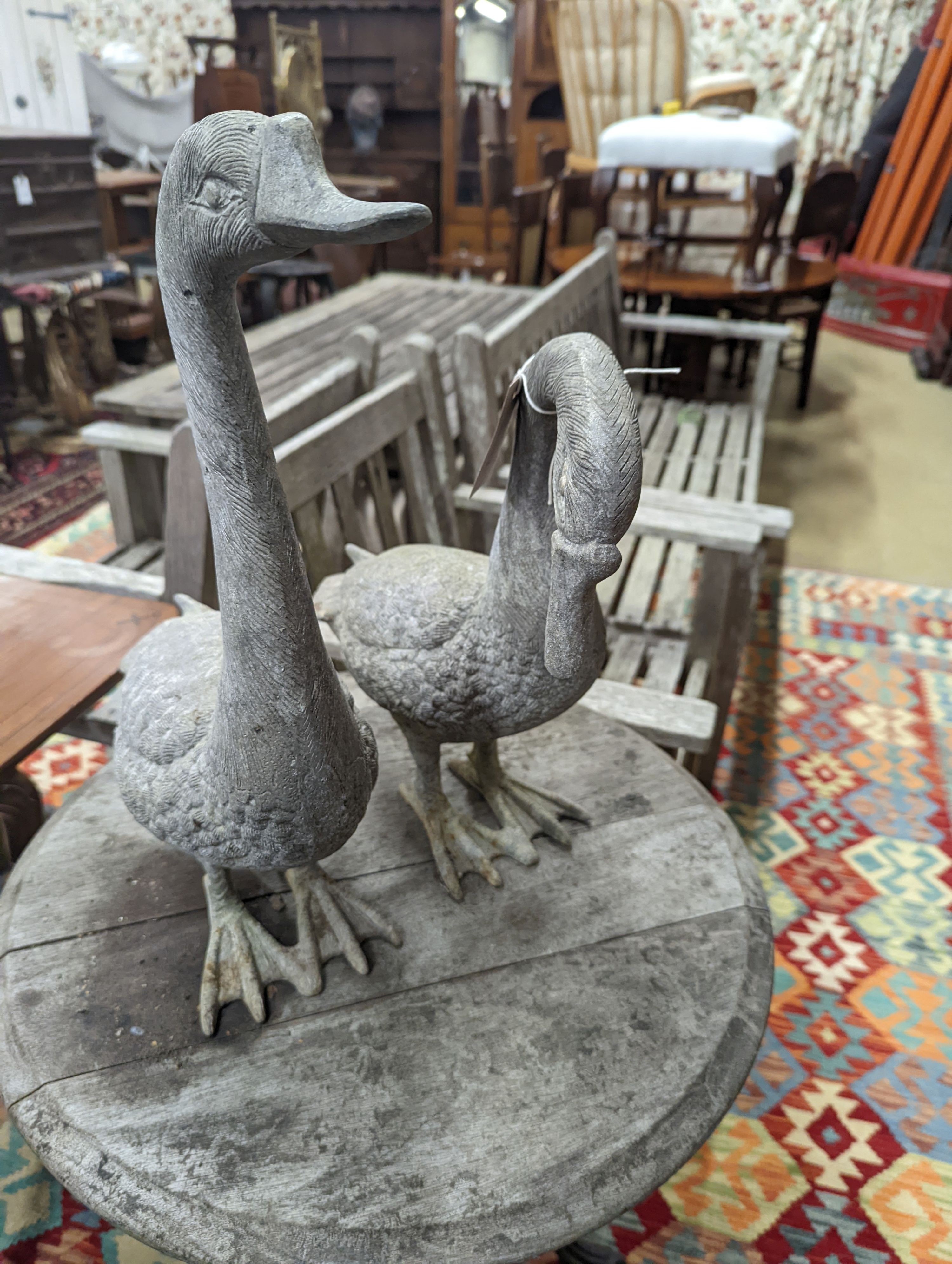 A pair of cast metal garden ornaments modelled as geese, larger height 51cm